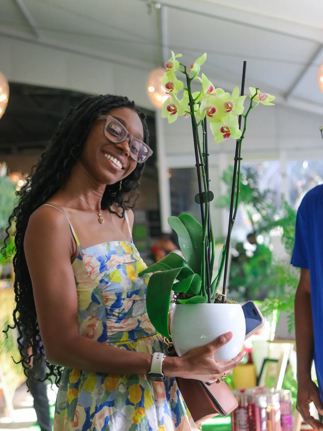 Customer holding a blooming orchid in a white pot