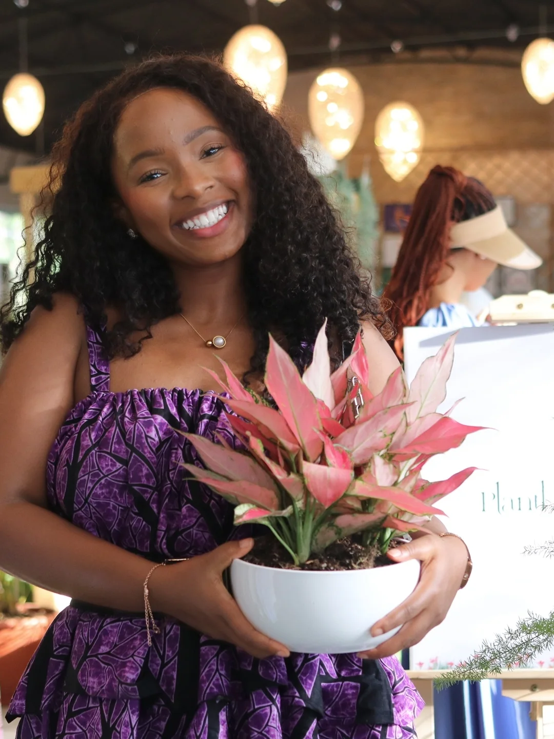 Customer holding a pink aglaonema plant